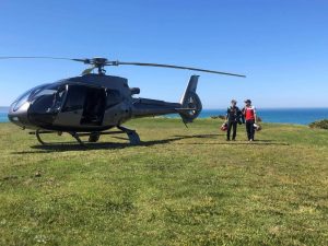 Two people standing next to the MotoGP Helicopter and waiting for transfer to Melbourne