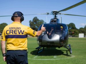 PHS crew member guiding MotoGP Helicopter to land during Melbourne one way transfer