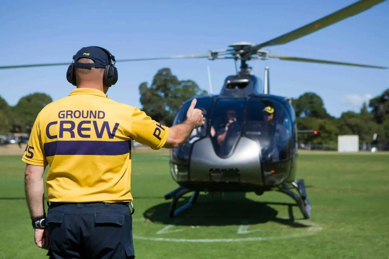 PHS crew member guiding MotoGP Helicopter to land during Melbourne one way transfer